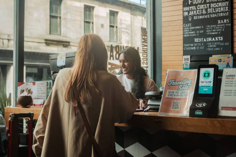 Friendly customer service interaction at St Christopher's café counter in a city setting.