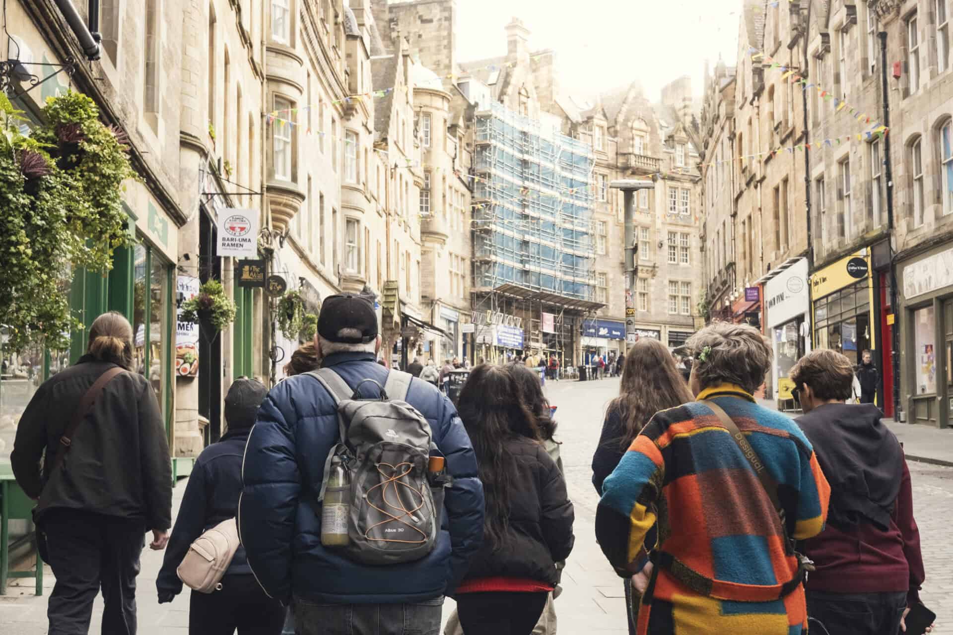 Group of diverse people walking in a city street with historic buildings.