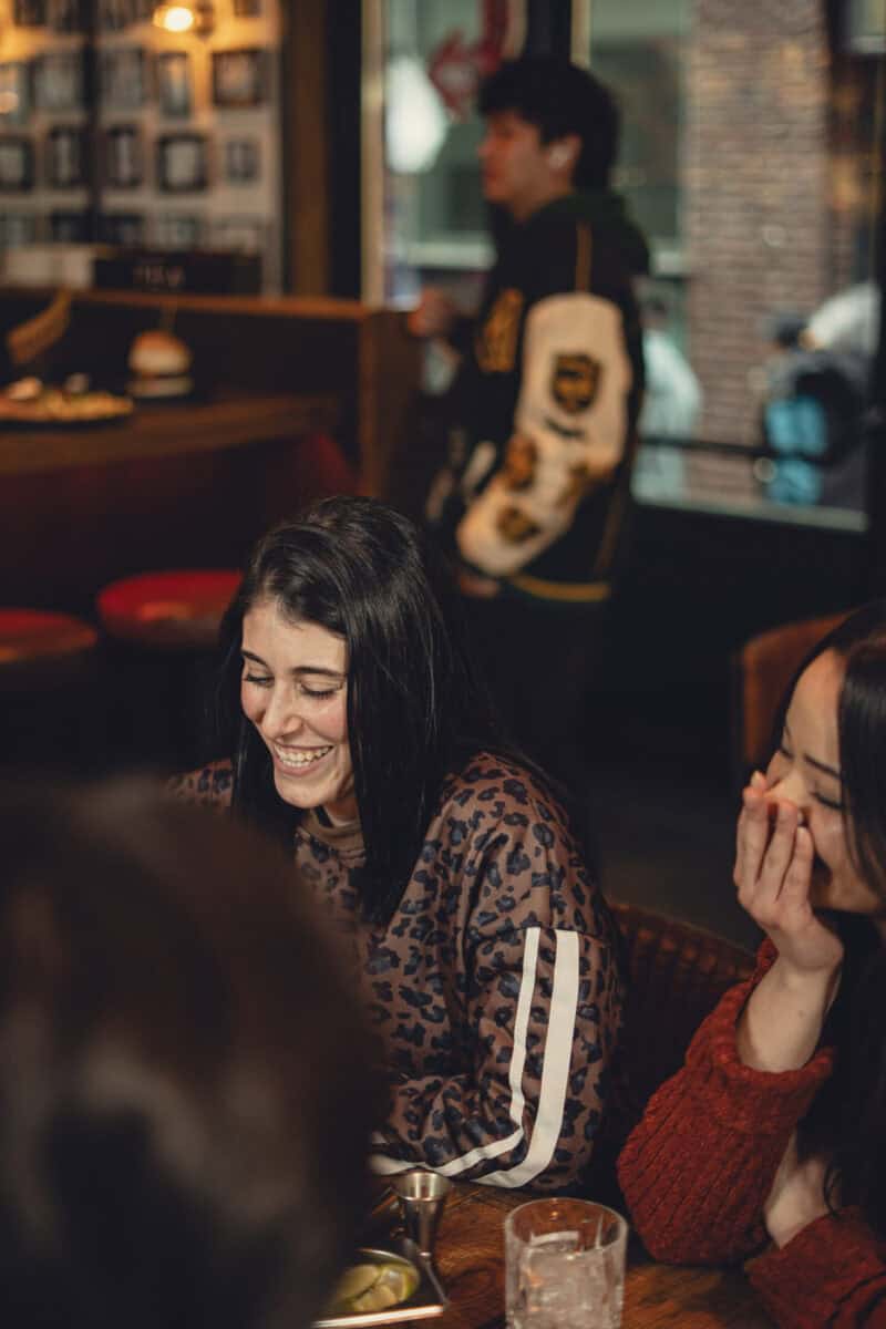 Guests enjoying socialising at St Christopher's Berlin - Mitte hostel in a lively bar setting.