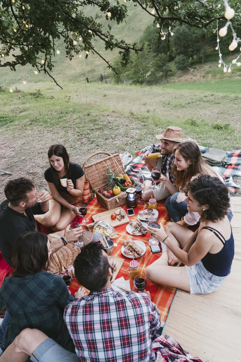 Group of friends enjoying a picnic outdoors under a tree at St Christopher's.
