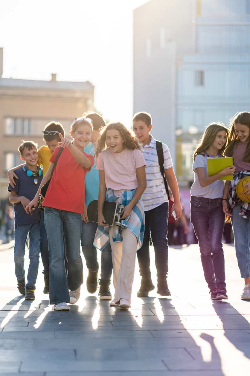 Group of diverse students walking together outdoors in an urban setting.