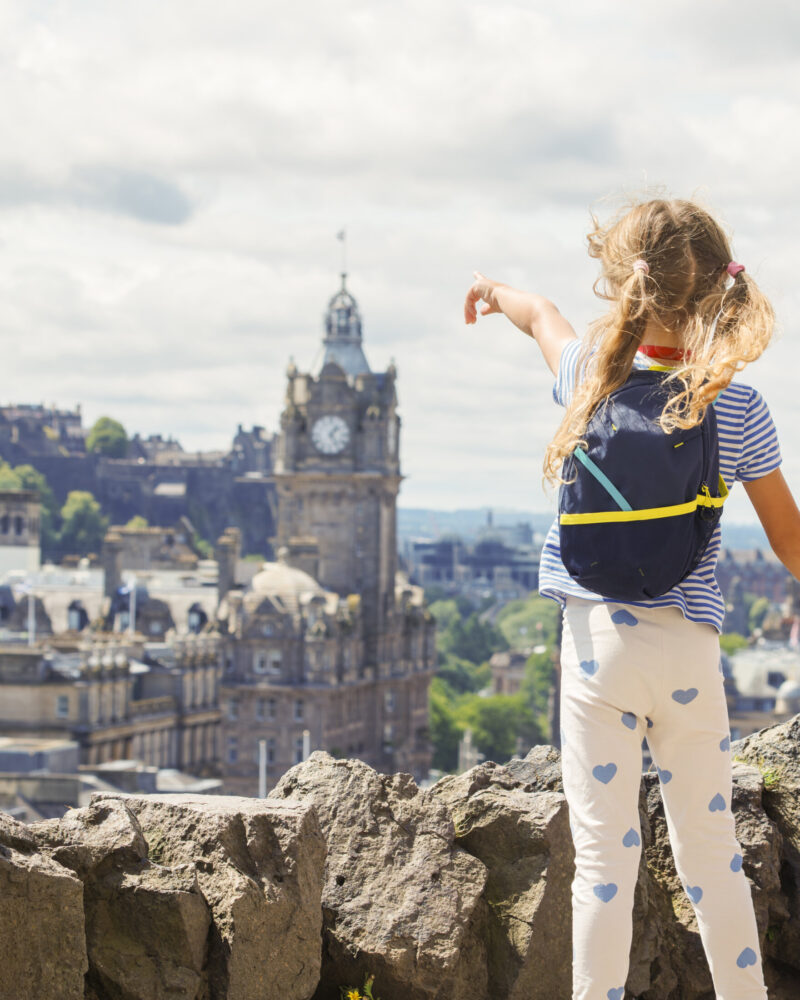 Children tourists enjoy scenic view over the city, holding hands