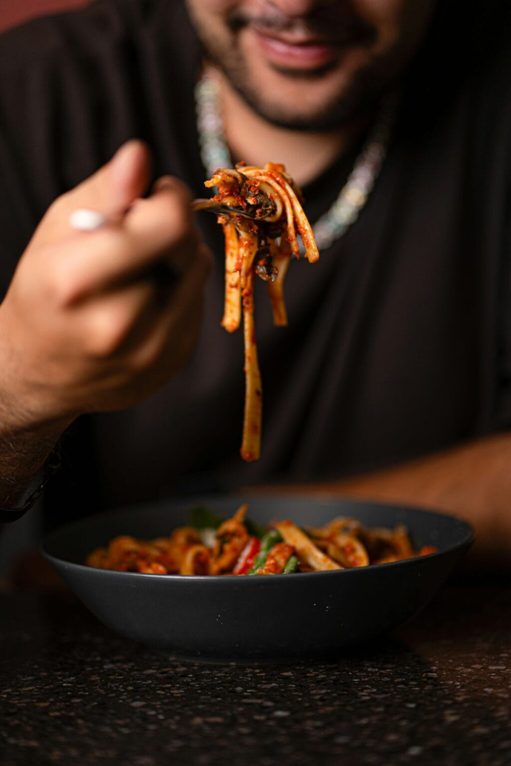 Man enjoying a bowl of spaghetti Bolognese with rich tomato sauce and herbs.