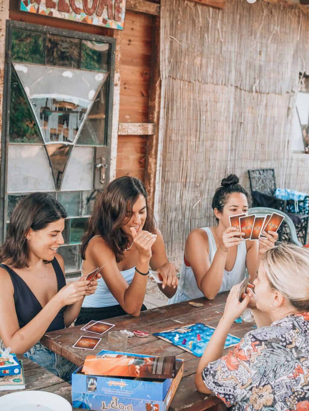 Group of women playing cards outdoors at St Christopher's, enjoying a social evening.