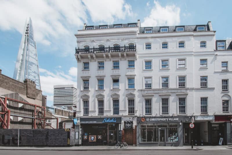 Historic white building in London with shops and hostel facilities.