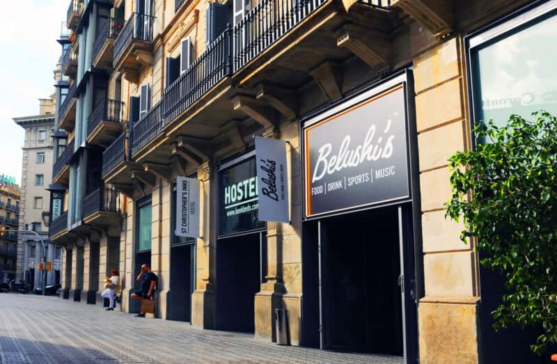 Entrance of St Christopher’s Barcelona hostel with signage and city street view.