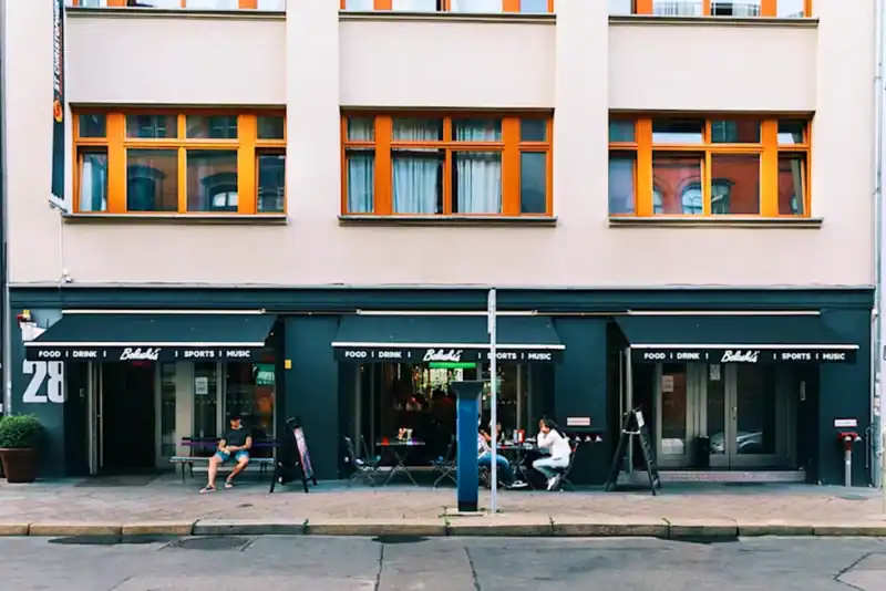 Modern Mitte Hostel in Berlin with vibrant exterior and outdoor seating area.